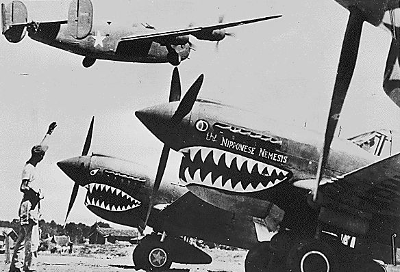  American ground crewman near shark-nosed P-40s waves 